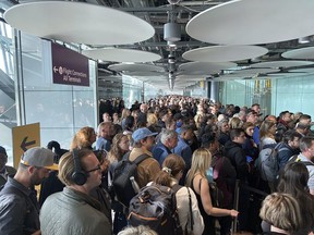 People queue at arrivals at Heathrow airport in London, Saturday, May 27, 2023. The British government is working to fix a technical problem that caused electronic border gates at airports around the country to stop working, leading to hourslong waits for travelers entering the U.K. at the start of a busy holiday weekend.