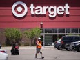 FILE - A worker collects shopping carts in the parking lot of a Target store on June 9, 2021, in Highlands Ranch, Colo. Target is removing certain items from its stores and making other changes to its LGBTQ merchandise nationwide ahead of Pride month, after an intense backlash from some customers including violent confrontations with its workers.