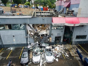 Emergency personnel survey a collapsed rooftop parking area  in Vancouver on Friday, July 15, 2022.