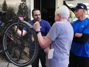 Lior Mirkin, sales manager at Trek Bicycle in Burnaby, shows an e-bike on May 29 to two potential customers.