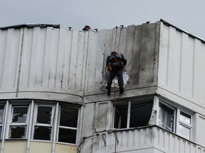 Workers repair damage on the roof of a multi-storey apartment block following a reported drone attack in Moscow, Russia, May 30.
