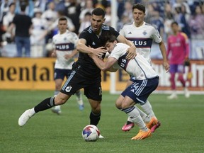 Minnesota United FC defender Michael Boxall battles for the ball against Vancouver Whitecaps FC forward Brian White during the first half at B.C. Place May 6, 2023.