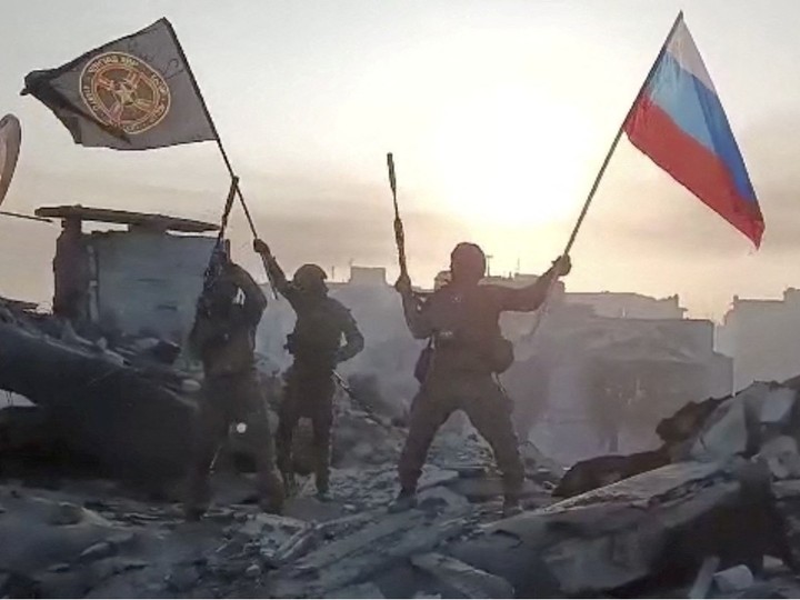  Wagner mercenary group fighters wave flags of Russia and Wagner group on top of a building in an unidentified location, in the course of the Russia-Ukraine conflict, in this still image obtained from a video released on May 20, 2023, along with a statement by Russian mercenary chief Yevgeny Prigozhin about taking full control of the Ukrainian city of Bakhmut.