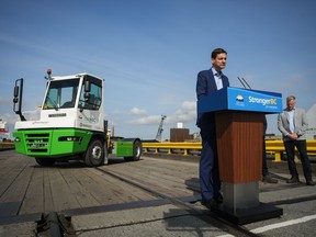 British Columbia Premier David Eby stands behind a height-adjustable podium during an announcement at the Seaspan Ferries Tilbury Terminal in Delta, B.C., on Thursday, April 27, 2023.