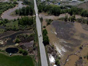 Overland flooding is seen as the swollen Bonaparte River runs through the Bonaparte First Nation while motorists travel on the Cariboo Highway, north of Cache Creek, B.C., on Sunday, May 14, 2023.