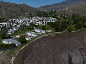 The swollen Bonaparte River flows past an evacuated mobile home community in Cache Creek, B.C., on Sunday, May 14, 2023. A flood warning has been issued for the Skeena region of northwestern British Columbia as unseasonably warm temperatures swell rivers in many areas of the province.