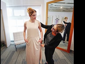 Olivia Hahn has a dress fitted by Rebecca Burrows, the owner of Hughes Clothing, for a fashion show to raise money for a cancer charity.