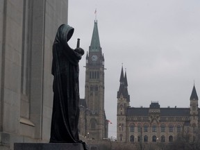 The statue representing justice looks out from the Supreme Court of Canada over the Parliamentary precinct in Ottawa, Thursday March 25, 2021.