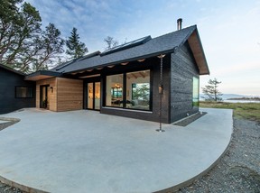 Raw cedar siding helps distinguish the home's entry from the rest of the exterior, which has sliding glass doors that open on all sides.