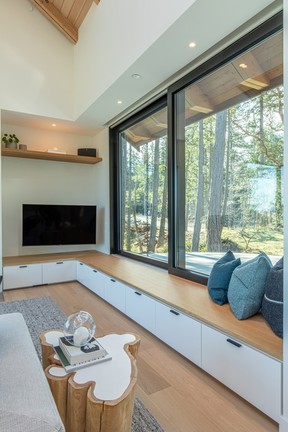 Large built-in bench in the living room provides storage as well as additional seating. Log-like side table from Mth Woodworks in Vancouver.