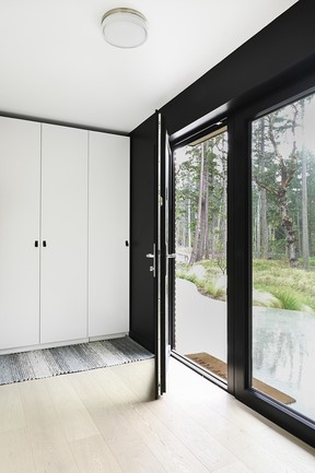 Ikea Pax units offer ample storage in the home's entryway, cleverly designed to appear built-in.