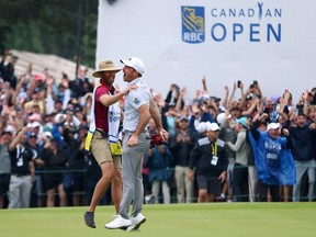Nick Taylor celebrates with his caddie after making an eagle putt on the fourth playoff hole to win the RBC Canadian Open at Oakdale Golf and Country Club in Toronto.