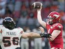 Calgary Stampeders quarterback Logan Bonner (right) throws a pass while being pressured by BC Lions' David Menard during the first half of CFL pre-season football action in Vancouver, B.C., Thursday, June 1, 2023. THE CANADIAN PRESS/Rich Lam