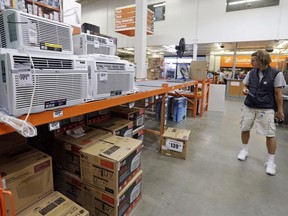 Patrick Burnette looks over fans and air conditioners at a Home Depot hardware store, Tuesday, Aug. 1, 2017, in Seattle. The British Columbia government is giving its Crown power utility $10 million to provide vulnerable people with free air-conditioning units.