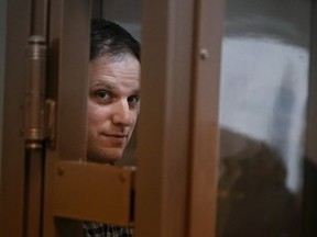 Reporter Evan Gershkovich stands in a glass cage in a courtroom at the Moscow City Court on Tuesday, April 18, 2023.