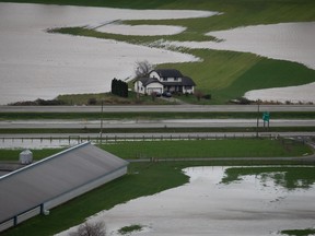 A house sits on high ground among flooded farmland in Abbotsford, B.C., on Wednesday, December 1, 2021. The final version of Canada's plan to make communities more resilient to the effects of climate change will be released today.