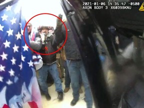 This image from police body-worn video, released and annotated by the Justice Department in the statement of facts supporting an arrest warrant for Markus Maly, shows Maly, circled in red, at the U.S. Capitol on Jan. 6, 2021, in Washington. (Justice Department via AP)