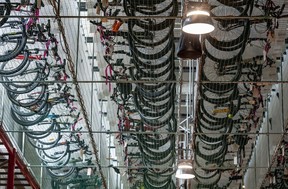 Recovered stolen bikes hang from a conveyor near the ceiling of the VPD property office in Vancouver.