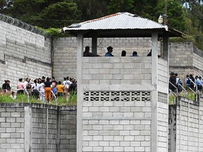 Prison guards watch inmates of the Women's Center for Social Adaptation prison following a deadly conflict between inmates in Tamara, Honduras on June 20, 2023.