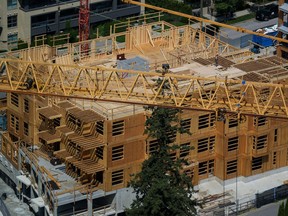 A construction worker is seen on top of a low-rise condo development being built in Coquitlam, B.C., on Tuesday, May 16, 2023. The Real Estate Board of Greater Vancouver says May home sales rose 15.7 per cent from a year earlier.