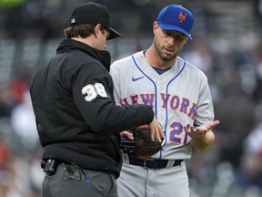 New York Mets pitcher Max Scherzer is checked by umpire Adam Beck on his way to the dugout.