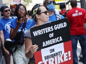 Striking WGA workers march in solidarity on the picket line outside the Ritz-Carlton hotel on July 3, 2023 in Los Angeles, California.