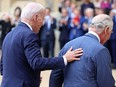 U.S. President Joe Biden places his hand on the back of Britain's King Charles III as they walk in the Quadrangle after ceremonial welcome at Windsor Castle on Monday.