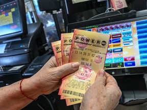 A woman holds Powerball lottery tickets inside a store in Homestead, Florida on July 19, 2023. The Powerball jackpot has reached 1 billion USD for the July 19, 2023, drawing, which has only happened two times before in the history of the game.