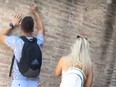 Ivan and Hayley? A tourist carves names into the Colosseum in Rome.