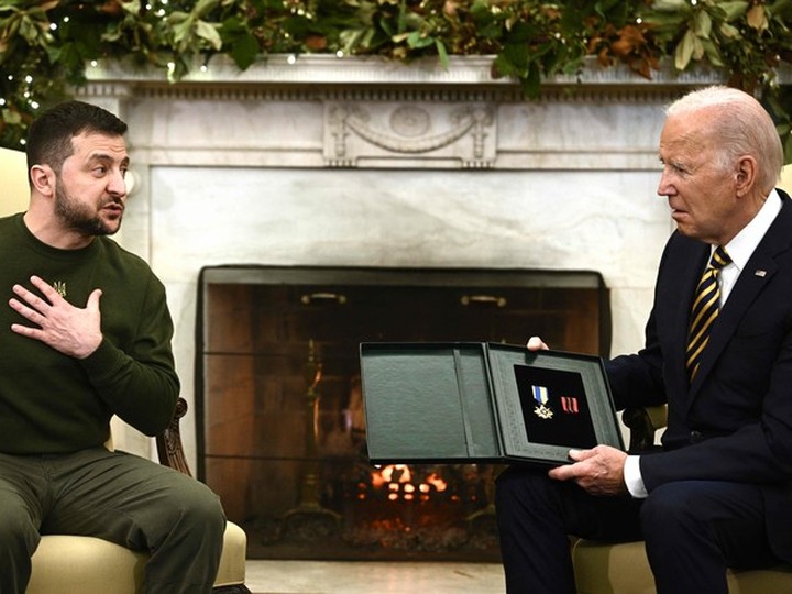  Ukraine’s President Volodymyr Zelensky gives a medal to US President Joe Biden in the Oval Office of the White House, in Washington, DC on December 21, 2022.