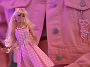 A woman holds a Barbie doll after watching the "Barbie" film at the SM North Edsa in Quezon City on July 19, 2023.