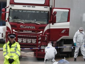 Forensic police officers attend the scene after a truck was found to contain a large number of dead bodies, in Grays, England, Oct. 23, 2019.