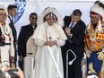 Pope Francis receives a traditional headdress after apologizing for the Roman Catholic Church's role in the residential school system, in Maskwacis, Alta., during his papal visit across Canada on Monday, July 25, 2022.