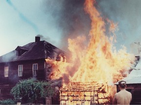 A naked Doukhobor woman watches a house burn as part of the group's protest in this June, 1962 photo.