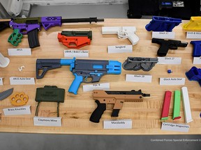 An array of 3D-printed weapons made out of colourful plastic are seen in a Tuesday, July 11, 2023, police handout photo. Included are replicas of commercially made firearms including an AR-15 rifle and handguns by arms manufacturers Glock and Smith & Wesson.