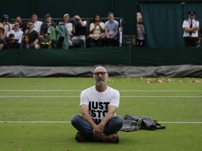 A Just Stop Oil protester sits on Court 18 on day three of the Wimbledon tennis championships in London, Wednesday, July 5, 2023.