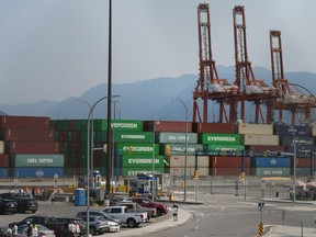 Striking International Longshore and Warehouse Union Canada workers picket at a port entrance in Vancouver, B.C., Tuesday, July 4, 2023. The organization that represents employers at roughly 30 strikebound ports in British Columbia says binding arbitration could end the six-day-old dispute.