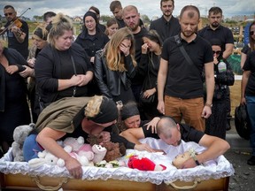Relatives and friends attend the funeral ceremony for Liza, 4-year-old girl killed by Russian attack, in Vinnytsia, Ukraine, Sunday, July 17, 2022. Wearing a blue denim jacket with flowers, Liza was among 23 people killed, including two boys aged 7 and 8, in Thursday's missile strike in Vinnytsia. Her mother, Iryna Dmytrieva, was among the scores injured.