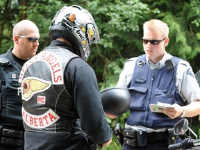 Police keep an eye on visitors coming and going from the Hell's Angels clubhouse in Langley on Saturday afternoon as the group hosted a 25th anniversary party.