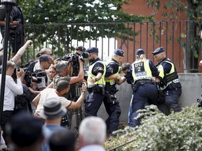 Police members try to restrain a man outside Stockholm's mosque at Medborgarplatsen, Sweden, Wednesday June 28, 2023. Stockholm police on Friday July 14, 2023 said they have authorized a protest this weekend by a man who has stated that he wants to burn the Torah and the Bible outside the Israeli Embassy in Stockholm.