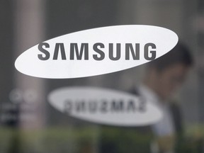 FILE - An employee walks past a logo of the Samsung Electronics Co. shown at its office in Seoul, South Korea. Samsung Electronics on Wednesday, July 26, 2023, unveiled two foldable smartphones as it continues to bet on devices with bending screens, a budding market that has yet to fully take off because of high prices.