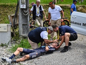 Firmenich's French rider Romain Bardet receives medical attention after a crash during the 14th stage of the 110th edition of the Tour de France cycling race, 152 km between Annemasse and Morzine Les Portes du Soleil, in the French Alps, on July 15, 2023.