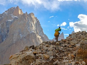 This picture taken on July 12, 2023, shows a Pakistani porter hiking on the trail between Askole and K2.