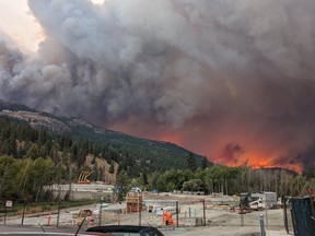 The McDougall Creek wildfire burns on the mountainside above houses in West Kelowna, B.C., on Thursday, August 17, 2023.