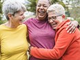 Three older women hugging, having fun