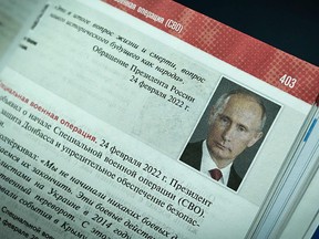 A photo of Russian President Vladimir Putin seen on a page of a new textbook for high school students in Russia, during its presentation in Moscow on August 7, 2023.