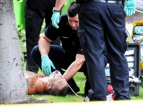 Paramedics tend to Larry Amero after the shooting in Kelowna that left Jonathan Bacon dead.