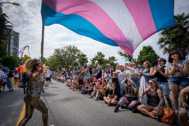 A person waves a trans pride flag during the Pride Parade at English Bay in Vancouver, B.C., Sunday, Aug. 6, 2023.
