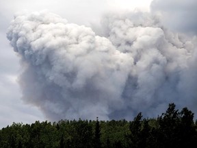 Smoke billows from the Donnie Creek wildfire burning north of Fort St. John, British Columbia, Canada, Sunday, July 2, 2023. Family, friends and colleagues are mourning a firefighter killed in northeastern British Columbia, the fourth fatality in one of the deadliest fire seasons in recent memory.