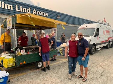 Rotarians Das Kandola (right) and Sandy Gilfillan were helping feed evacuees on Sunday outside Jim Lind Arena, West Kelowna's emergency support services centre during the wildfire. Kandola's uncle lost his home.